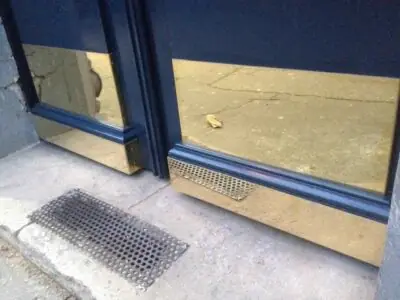 Porte chêne moulurée sur rue 129 avenue de Saint-Ouen détail laiton poli